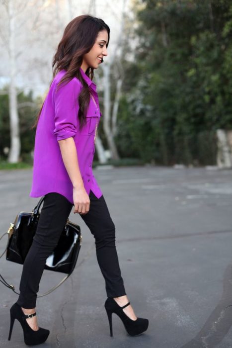 Chica con blusa morada y pantalón negro con tacones de plataforma