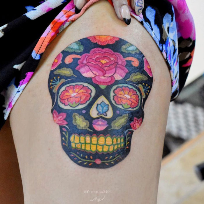 Fernanda Ramírez, tatuadora mexicana crea tatuajes bordados; calavera de día de muertos con flores en la pierna