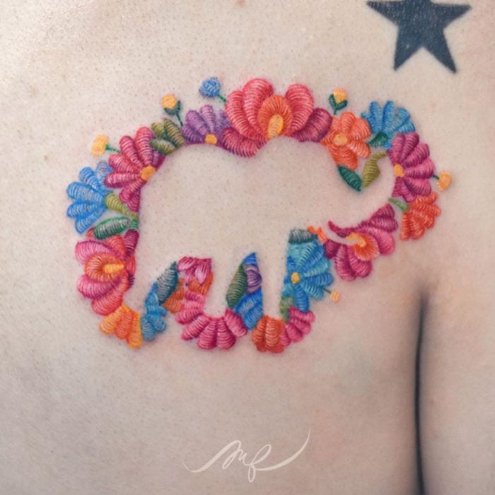 Fernanda Ramírez, tatuadora mexicana crea tatuajes bordados; silueta de elefante con flores en la espalda