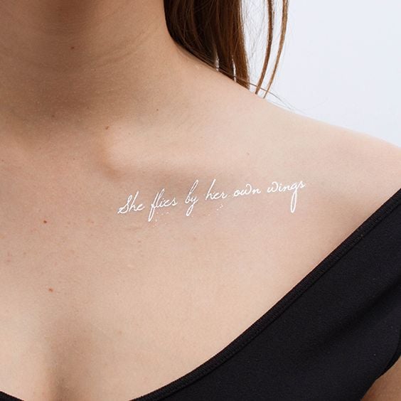Tatuaje de frase motivadora con tinta blanca