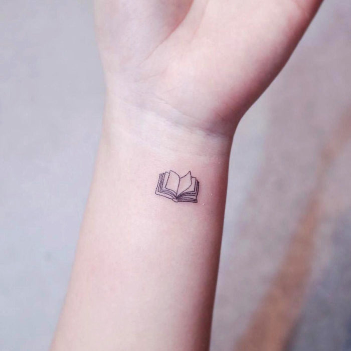 Tatuajes pequeños en la muñeca; libro abierto