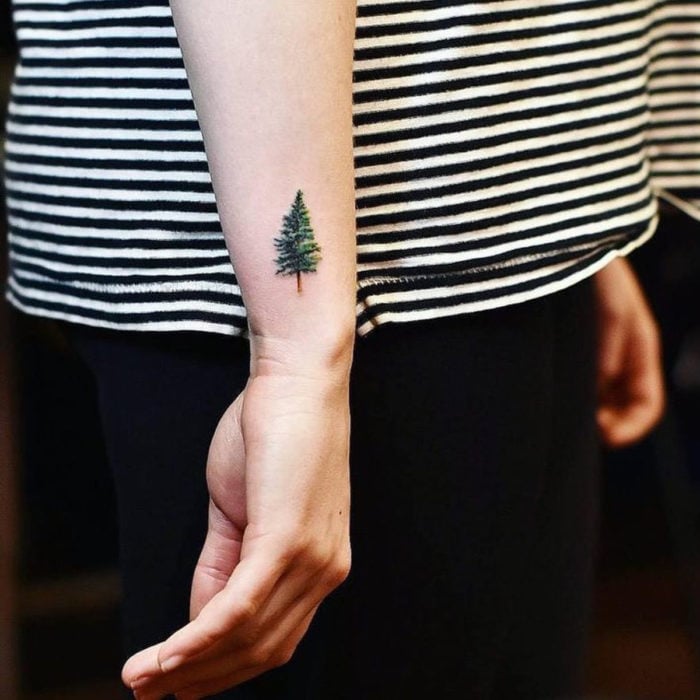 Tatuajes pequeños en la muñeca; árbol pino