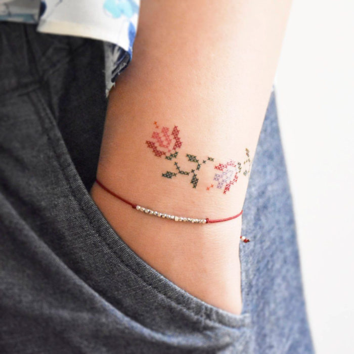 Tatuajes pequeños en la muñeca; flores tejidas