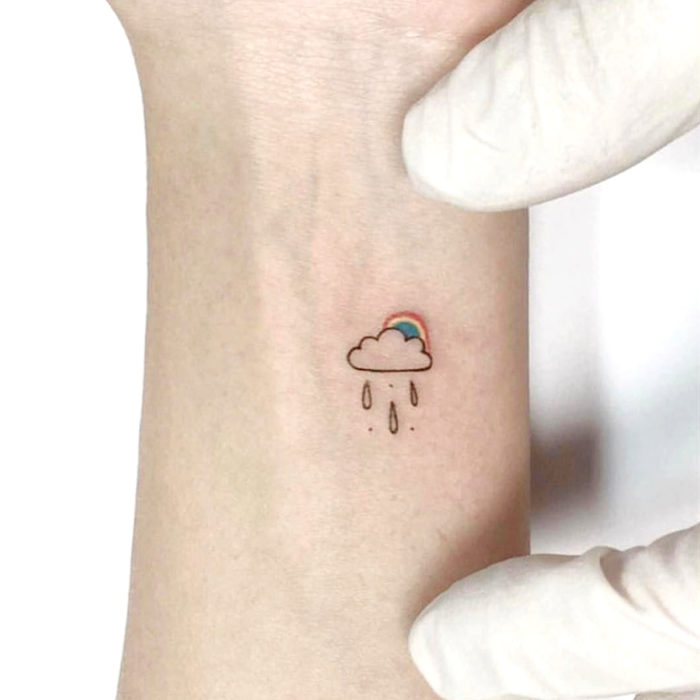 Tatuajes pequeños en la muñeca; nube con arcoíris 