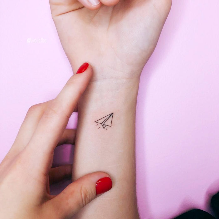 Tatuajes pequeños en la muñeca; avión de papel