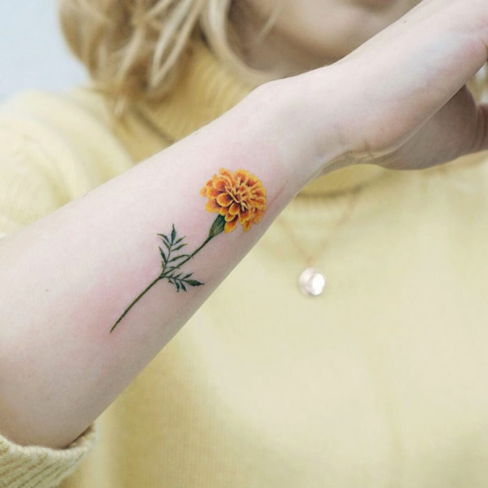 Tatuajes temporales; flor de cempasúchil en el brazo