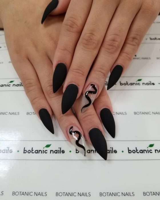 Uñas de tipo stiletto en color negro con una vivora 