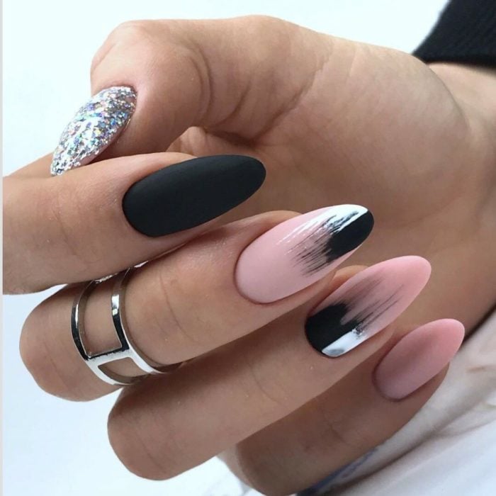 Chica con las uñas en forma de almendra y pintadas en color negro con rosa 