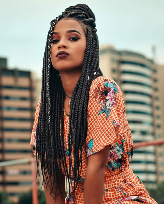 Looks con trenzas africanas; mujer morena de cabello largo y castaño