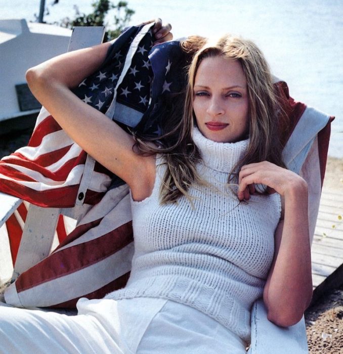 Uma Thurman acostada en una cama de sol con outfit blanco