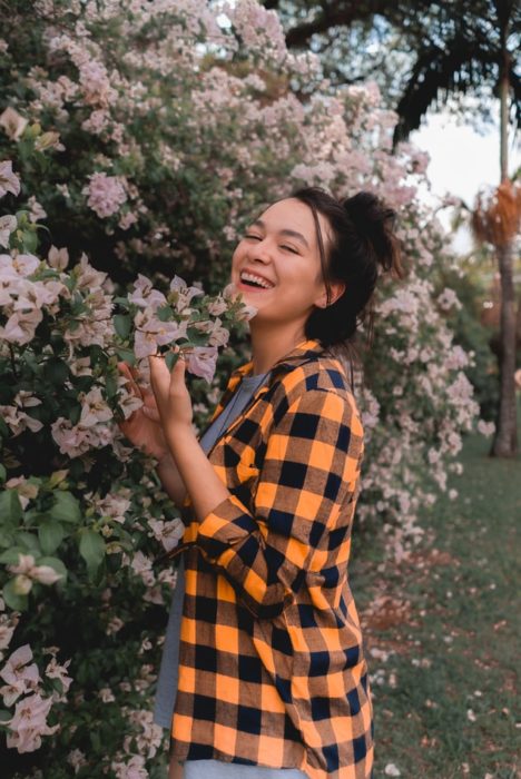 Mujer riendo tocando flores