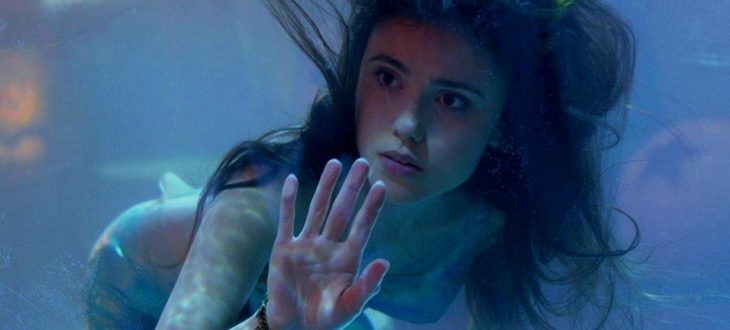 Poppy Drayton como sirena dentro de una pecera gigante en la película La sirenita del 2018