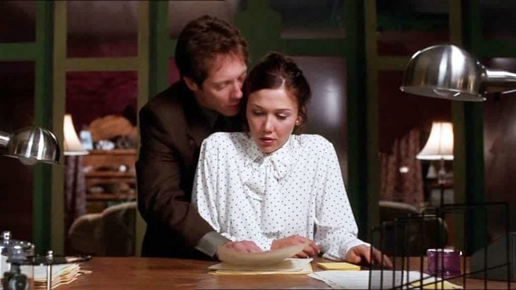 Escena de la película Secretary con Maggie Gyllenhall llevando camisa blanca con puntos negros