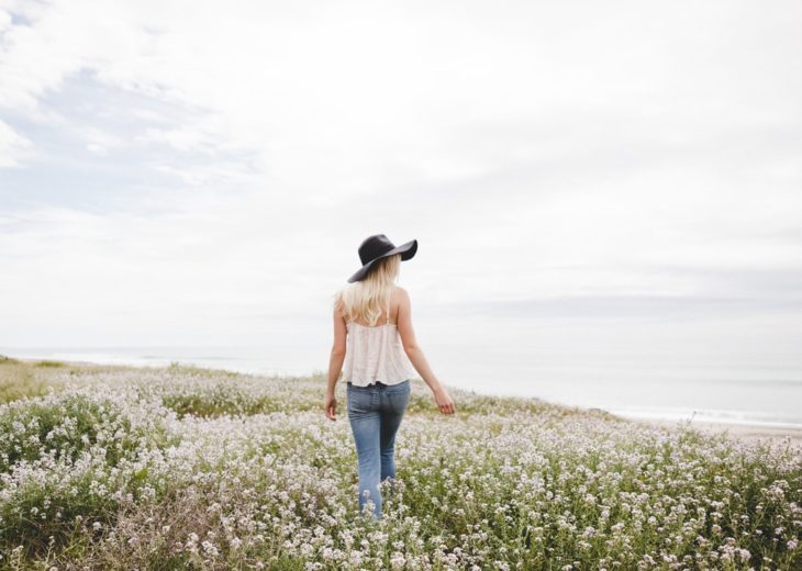 Chica caminando en campo de flores