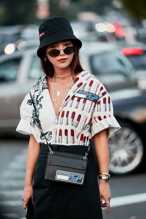 Chica con falda negra y camisa d estampados de labiales