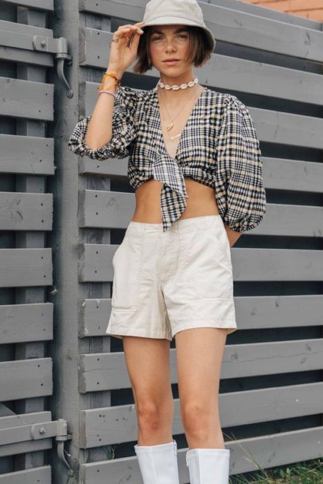 Chica con short blanco, crop-top a cuadros y un sombrero estilo pescador