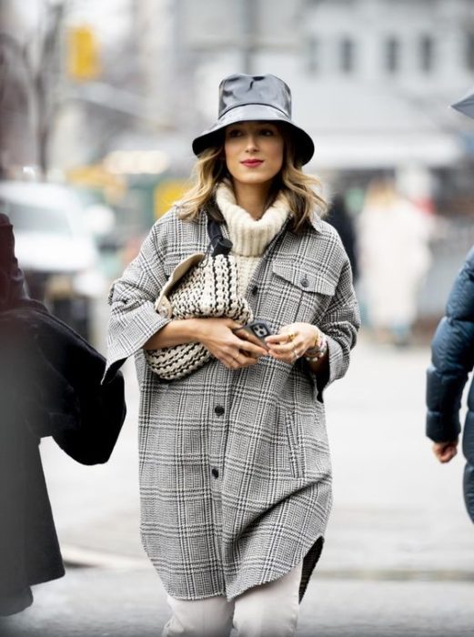 Chica con saco a cuadros y sombrero negro estilo pescador