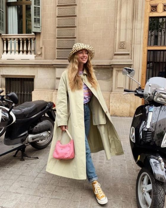 Chica con gabardina en tono verde limón con sombrero estilo pescador