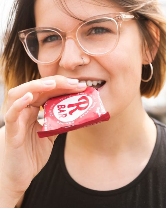 Chica de lentes comiendo un chocolate