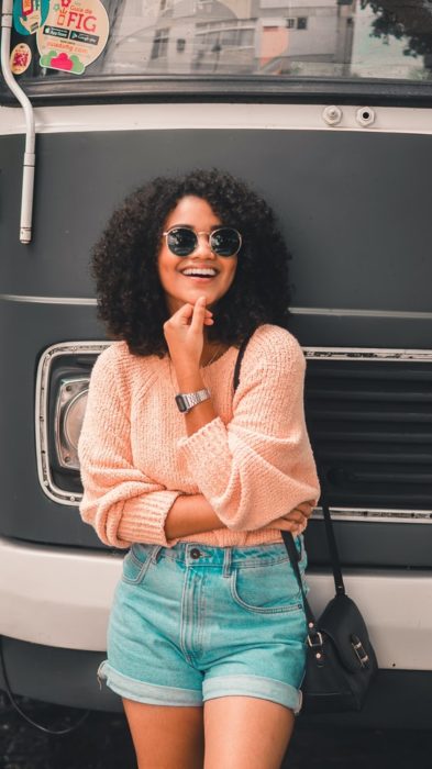 Chica de cabello rizado usando gafas de sol