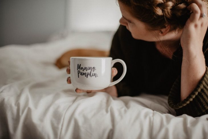 Mujer tomando café en un taza color blanca