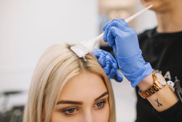 Chica decolorando la raíz de su cabello