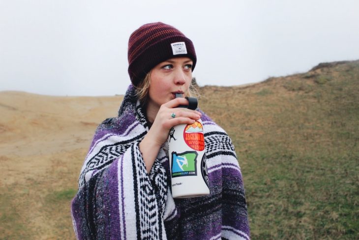 Chica bebiendo agua de un termo