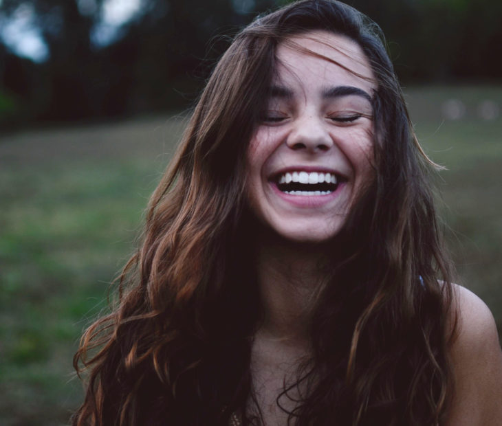 Chica sonriendo con los ojos cerrados