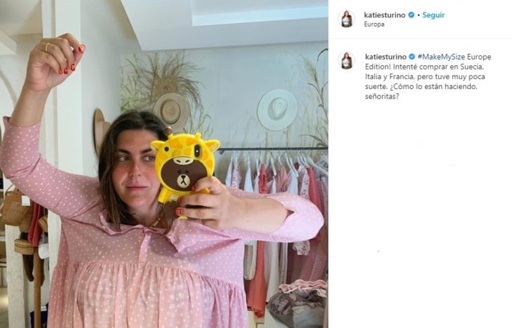 Katie Sturino tomando una selfie dentro de un provador con un vestido rosa palo que no va a acorde a su talla 