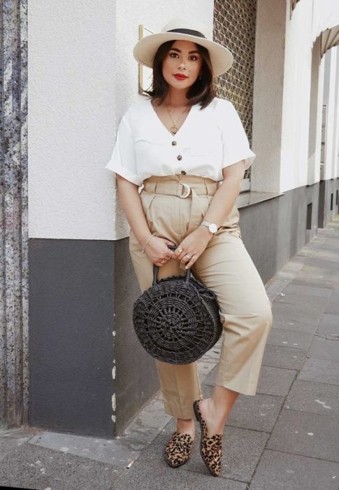 Chica curvy con pantalón beige amplio y blusa blanca