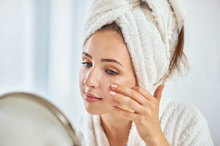 Chica aplicando crema en su rostro