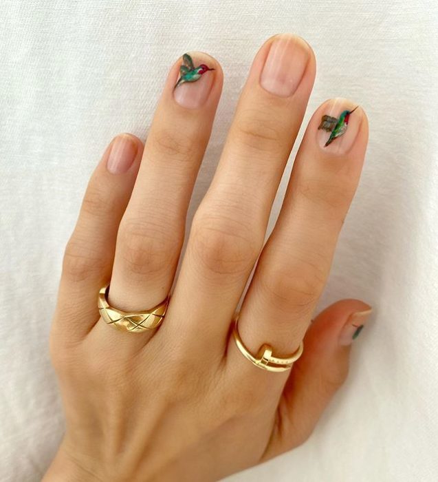 Diseños de uñas de Betina Goldstein con colibries de colores en cada tercer dedo 