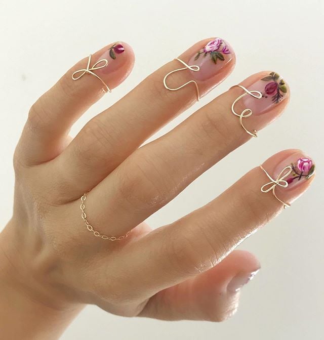 Diseños de uñas de Betina Goldstein con flores de color morado y rosa 