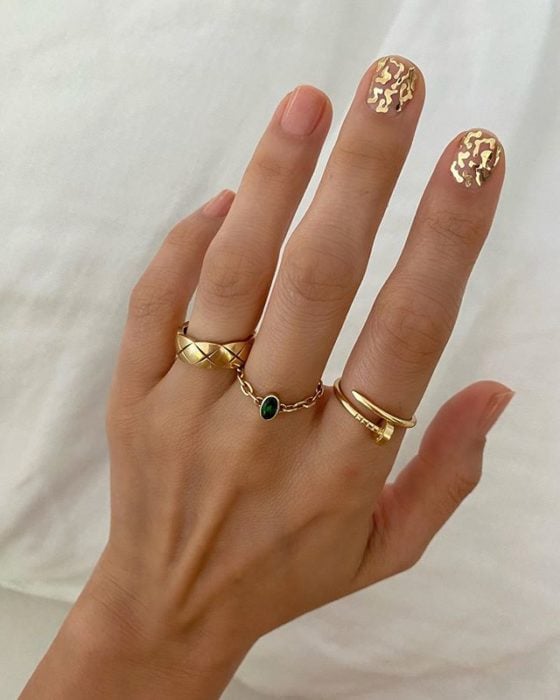 Diseños de uñas de Betina Goldstein con pequeñas estrellas doradas solo en el dedo indice y medio