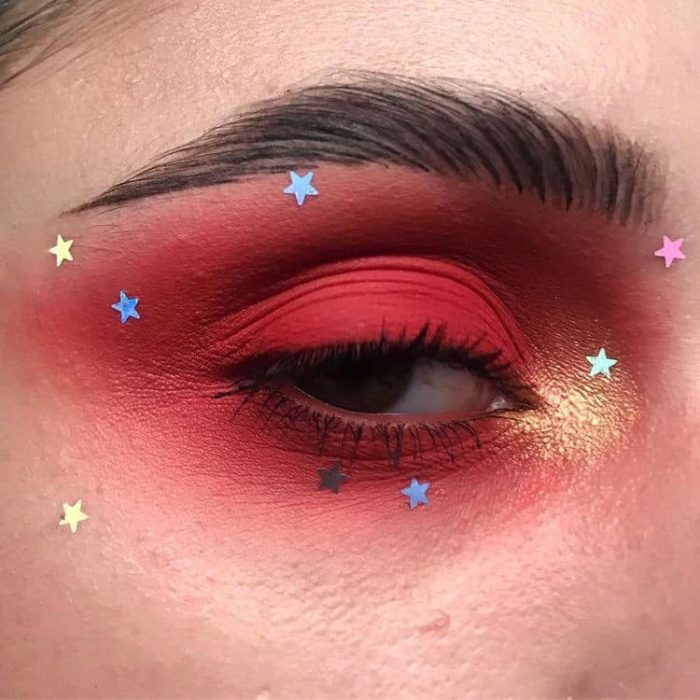 Maquillaje galáctico con tonos rojos y tornasol