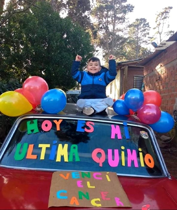 Niño celebra que venció al cáncer con carteles y globos de colores