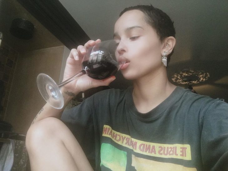 Zoe Kravitz con el cabello corto bebiendo una copa de vino 