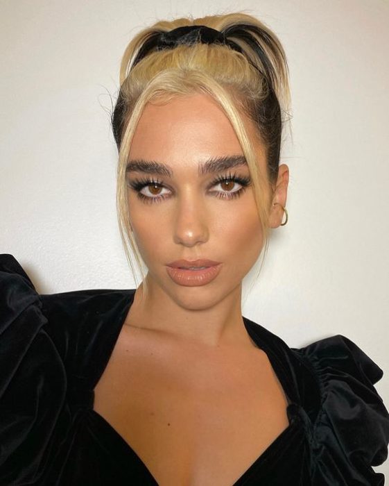 Dua Lipa con mechón de cabello beige enfrente 