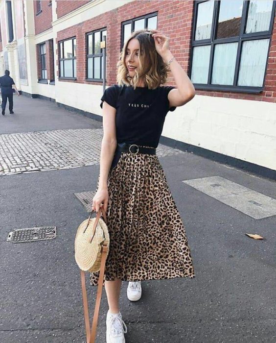 Chica usando una falda midi con estampado animal print con una blusa de color negro