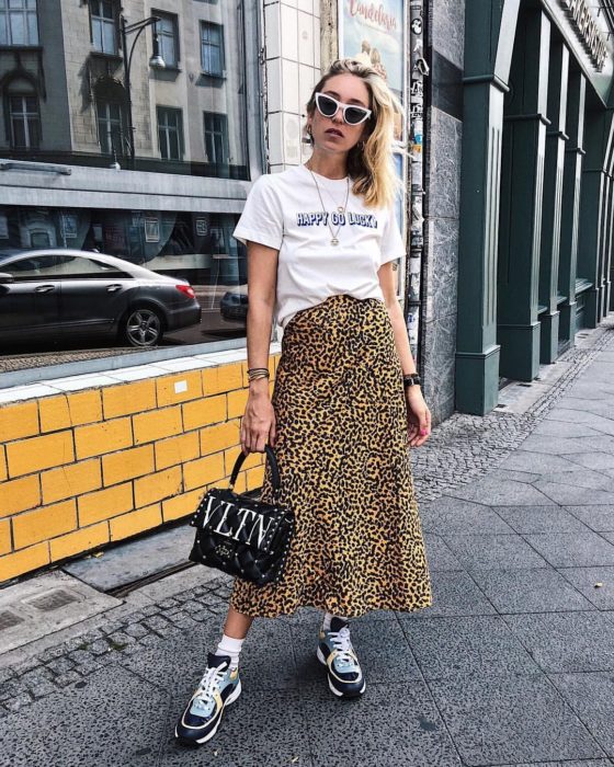 Chica usando una falda midi con estampado animal print con una blusa de color blanco con estampado 