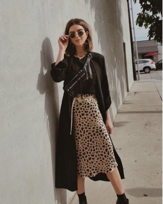 Chica usando una falda midi con estampado animal print con una blusa de color negro