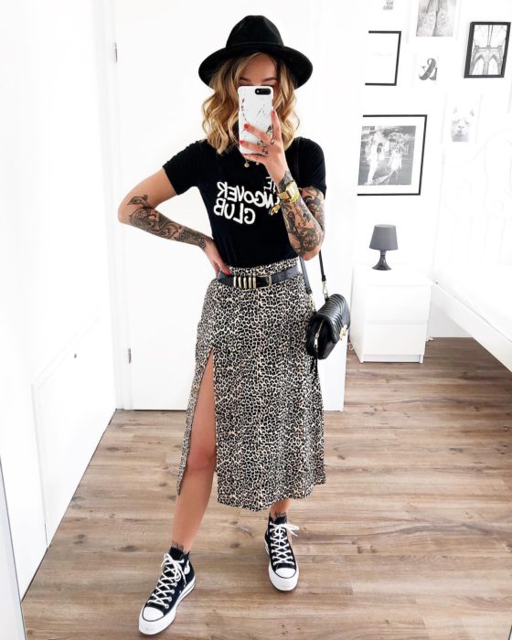 Chica usando una falda midi con estampado animal print con una blusa de color negro