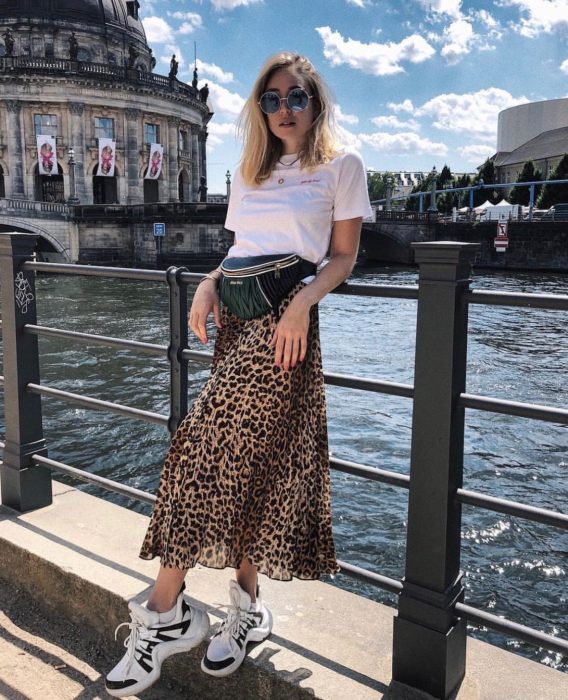 Chica usando una falda midi con estampado animal print con una blusa de color blanco