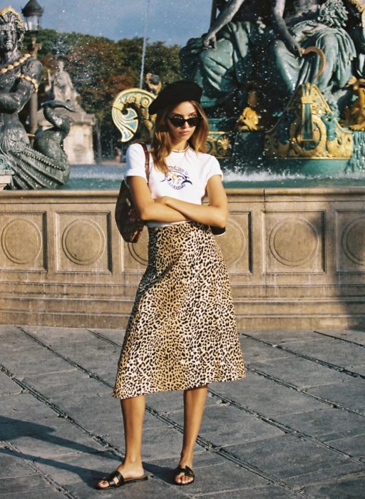 Chica usando una falda midi con estampado animal print con una blusa de color blanco 