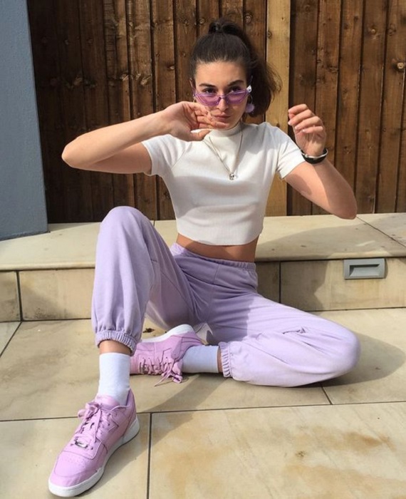 Chica usando outfit deportivo, con pants color lavanda y tenis del mismo tono