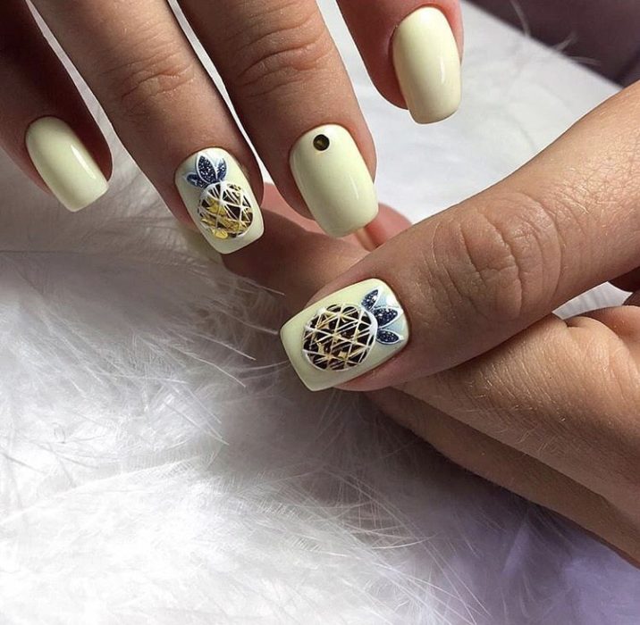 Manicura amarillo pastel con decorado de piñas en forma de diamantes