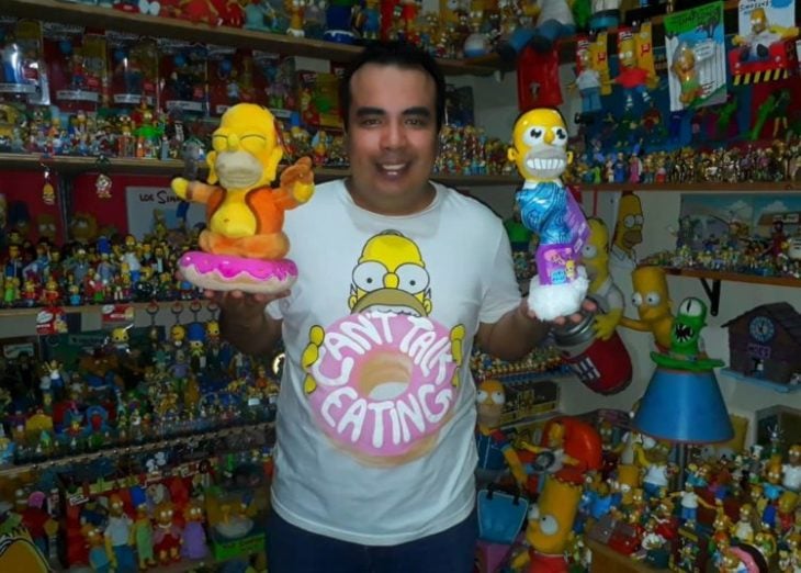 Hombre sosteniendo figuras de Los Simpson en sus manos