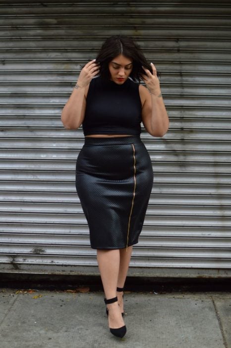 Chica curvy con una falda de cuero y un top de color negro 