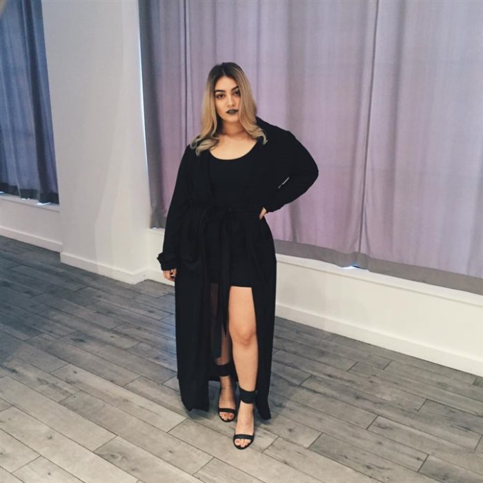 Chica curvy con un vestido de color negro con abertura 