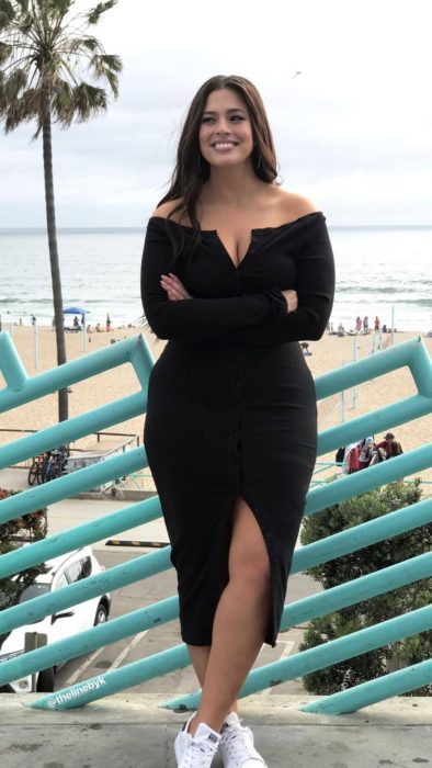 Chica curvy con un vestido de color negro de escote corazón y hombros descubiertos 